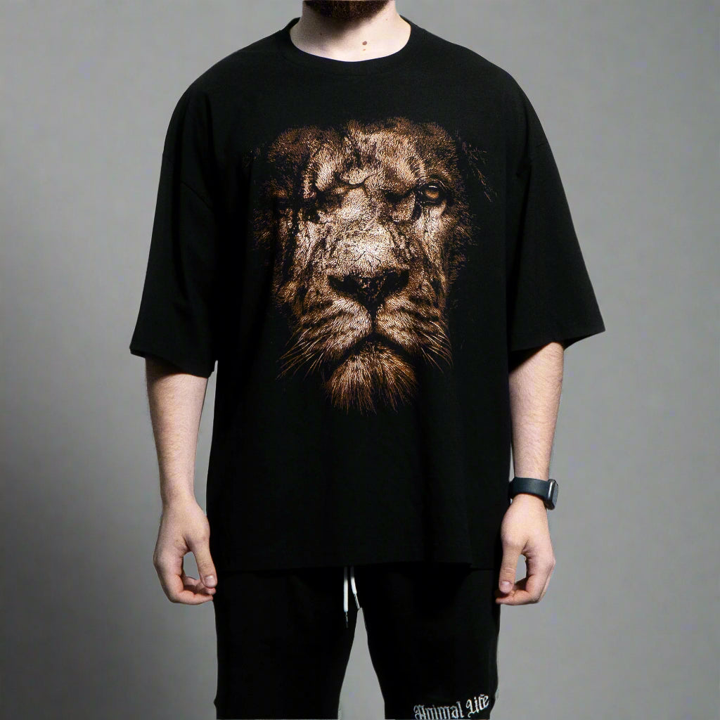 Person wearing a black t-shirt with a lion graphic design on a gray background